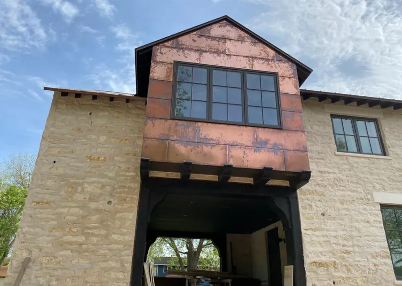 Copper metal panel facade on a stone building for Skylight Installation in Rusk